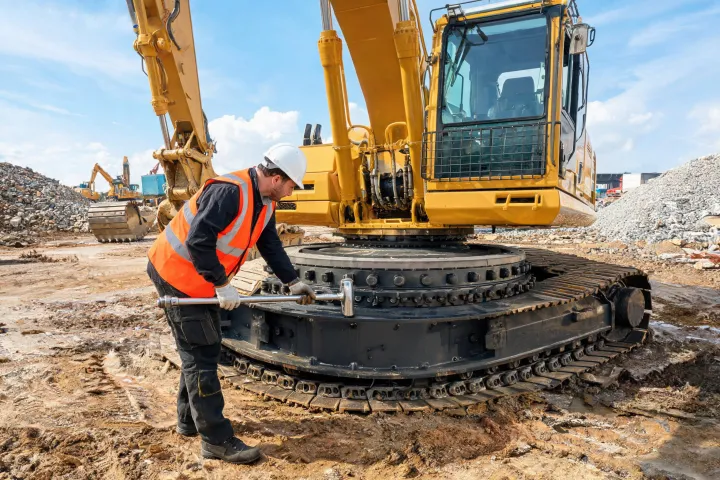 Field service engineer inspecting excavator slew bearing