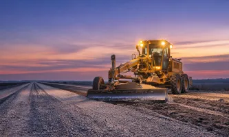 Motor grader shaping highway base course